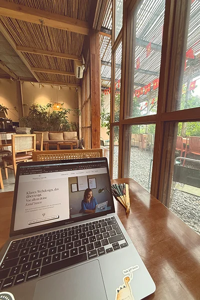 Laptop mit Onepager Website für Selbstständige auf einem Tisch im Café